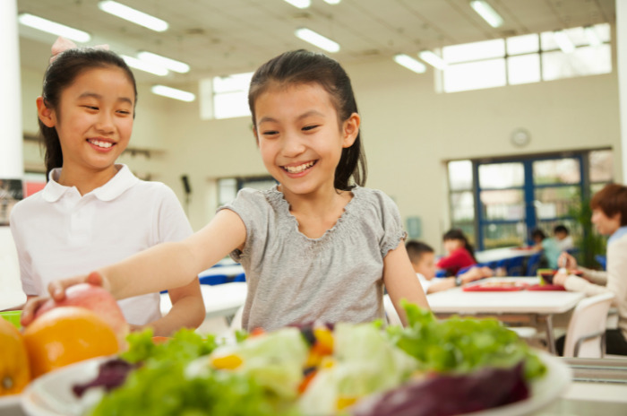 Young girls choosing school lunch