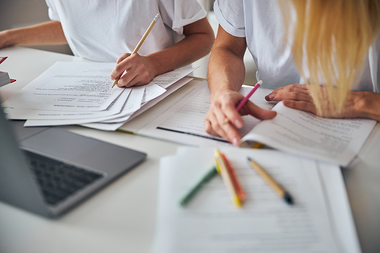 two-people-with-pencils-working-with-documents